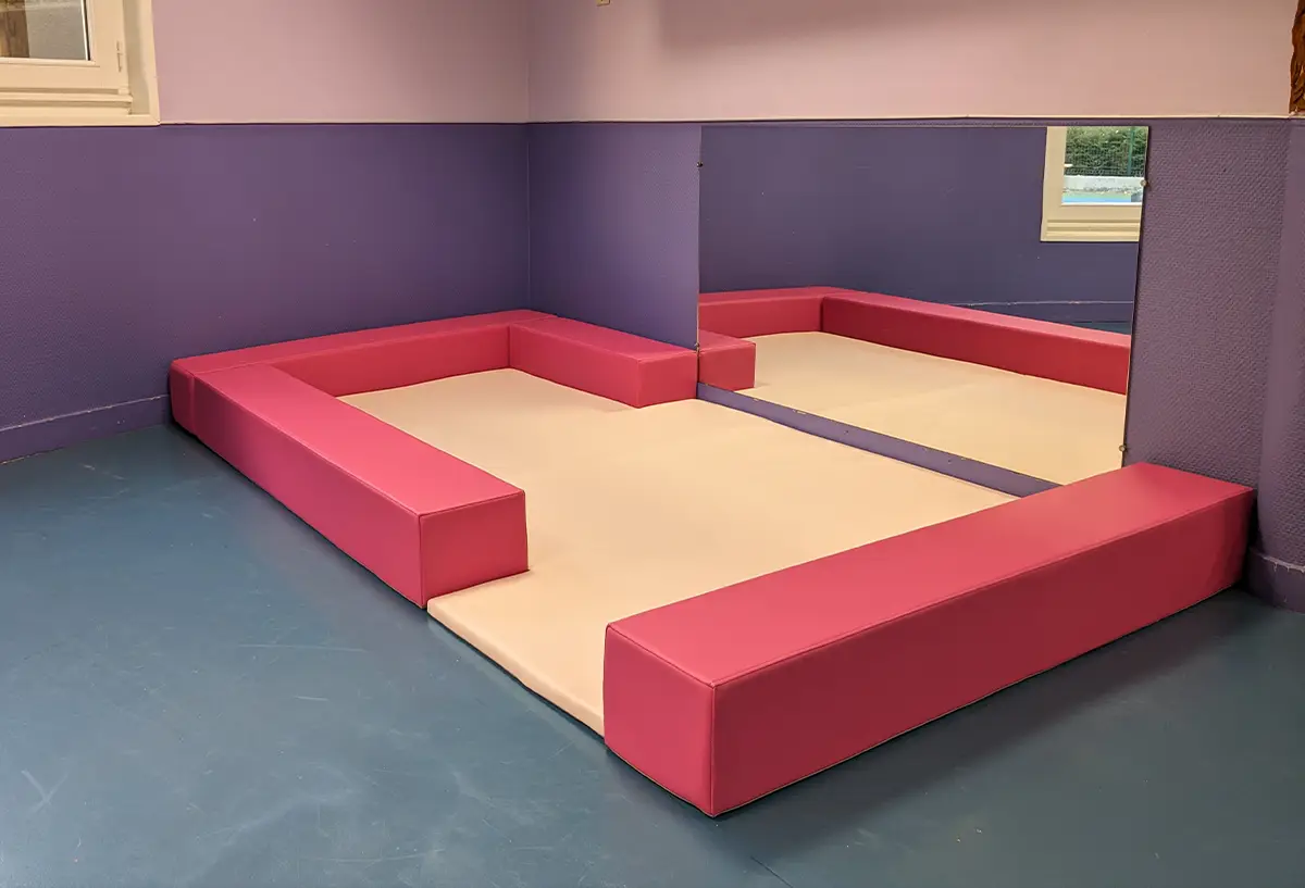 espace de regroupement avec tapis et poutres pour crèche