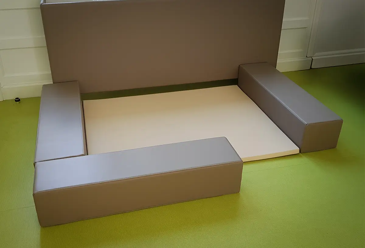 espace de regroupement avec tapis et poutres pour crèche