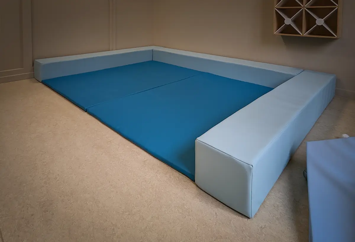 espace de regroupement avec tapis et poutres pour crèche