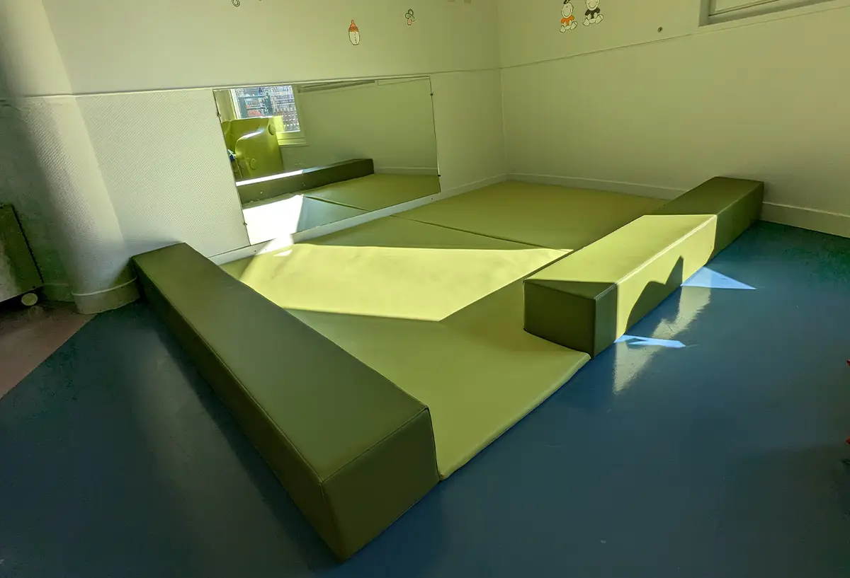 espace de regroupement avec tapis et poutres pour crèche